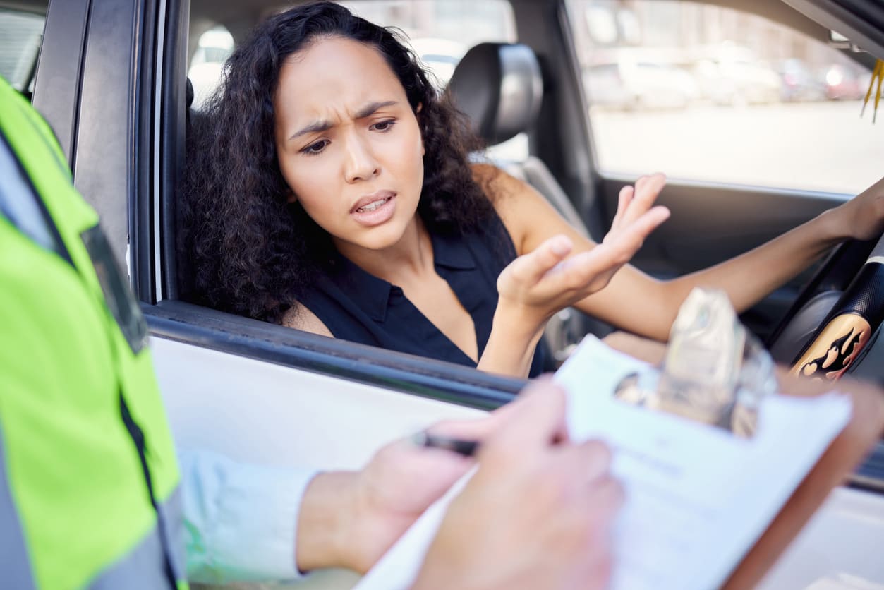 Agente de tránsito entrega una multa a una mujer conductora por no tener seguro de auto en República Dominicana
